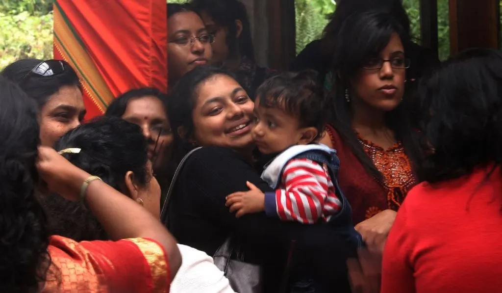 Female devotees dressed in saris wait for the Lord Murugan Temple to open at Skanda Vale Ashram