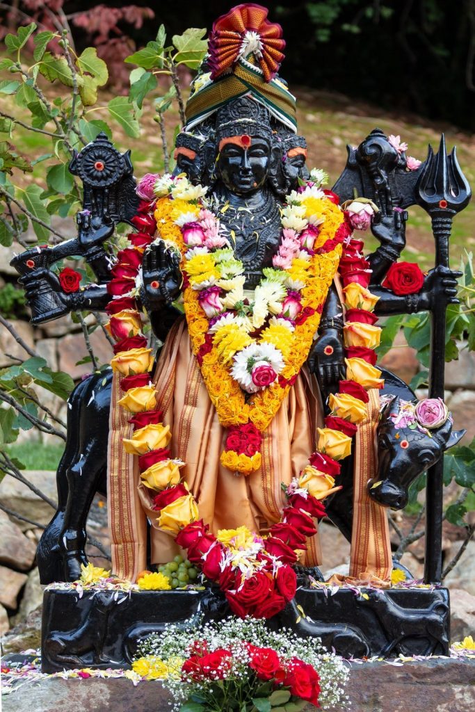 A sacred murthi of Lord Dattatreya with flower garlands at Skanda Vale