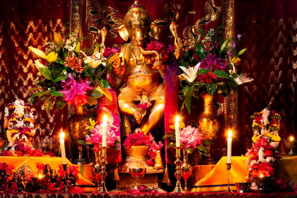 A beautiful shrine to Lord Ganesh with flowers and lamps