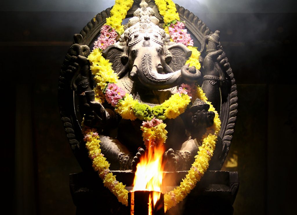 A stone murthi of Ganesha with fire lamp