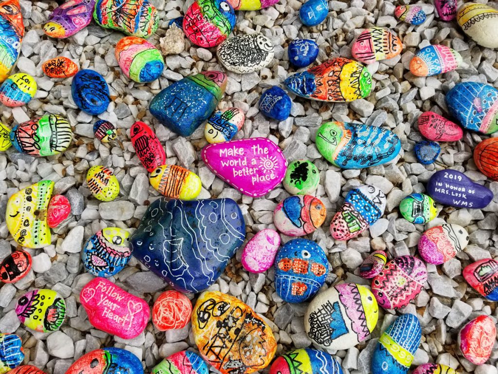 Pebbles on a beach painted by children