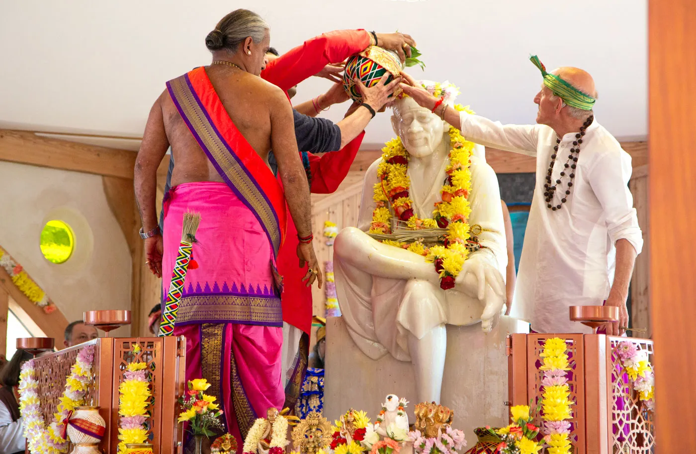Priests pour sacred water over the murthi of Shirdi Sai Baba