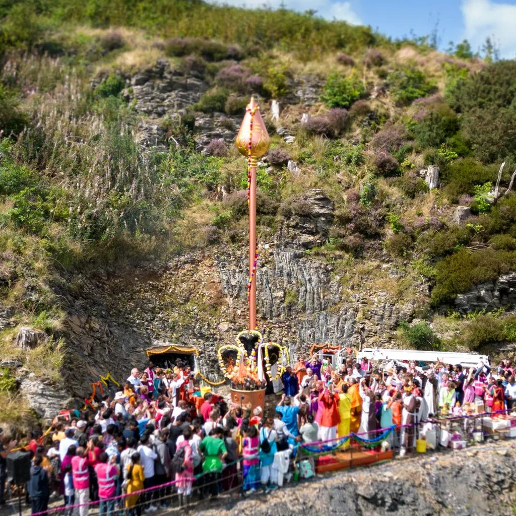 Lord Murugan's Vel on a hilltop with devotees praying